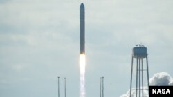 Joshua Wong (center left) and Alex Chow as they join other Umbrella Movement leaders unfurling umbrellas at the rally marking the one-month point since the beginning of the protests in Hong Kong (Ivan Broadhead/VOA).
