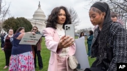 2024年3月13日,TikTok的忠实用户莫娜·斯温(Mona Swain,中)和她的妹妹瑞秋·斯温(Rachel Swain,右)(均来自亚特兰大)在国会大厦前参加一场支持TikTok的集会。美国国会众议院当天通过一项法案,如果 TikTok在中国的所有者不出售该应用程序,将在全国范围内禁止使用该流行视频应用程序。
