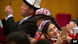 2016年3月8日,中国人大会议期间新疆代表在北京人民大会堂的用智能手机拍照。