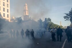 Tear gas floats in the air as a line of police move demonstrators away from St. John's Church across Lafayette Park, near the White House, in Washington, June 1, 2020.
