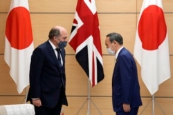 日本首相菅义伟在东京会晤到访的英国国防大臣本∙华莱士。(2021年7月20日)
