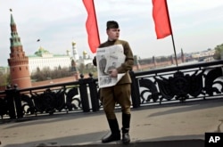 共产党支持者穿着第二次世界大战时的苏联红军军服,抱着印有斯大林像的苏共喉舌《真理报》,在莫斯科的五一节集会中(2010年5月1日)