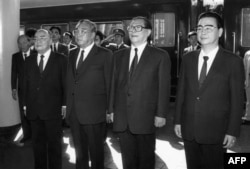 1991年10月4日朝鲜领导人金日成抵达北京火车站,在欢迎仪式上演奏国歌时,和中国领导人一起肃立。他站在中国国家主席杨尚昆和中共总书记江泽民之间,最右侧是李鹏总理。