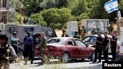 以色列士兵聚集在基亚特·阿巴定居点入口处,他们开枪击毙了一名开车撞击以色列人车辆的巴勒斯坦妇女。(2016年6月24日)