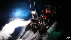 2014年2月23日在南极海,海洋守护者协会的一个橡皮艇上的活动人士试图用绳子套住一只日本捕鲸船