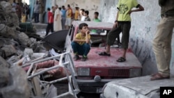 Người dân Palestine lặng nhìn cảnh hoang tàn của ngôi nhà năm thành viên gia đình Ghannam bị giết trong cuộc tấn công bằng tên lửa ở trại tỵ nạn Rafah, miền nam dải Gaza, do Israel thực hiện, 11/7/2014.