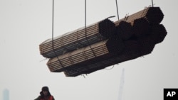 在中国唐山曹妃甸港口,工人把钢管装船。(2012年2月20日)中国钢铁产品受到欧盟制裁