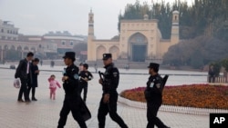 资料照：中国新疆喀什警察在一座清真寺前巡逻。 （2017年11月4日）