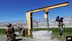 在墨西哥城市蒂华纳和美国加州城市圣迭戈之间所挖的地道的入口处,边界巡逻员在工作(2017年3月6日)