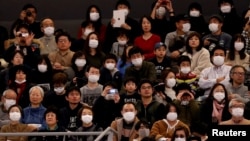 人们戴着口罩参加在日本东京都有明体育场举行的开幕式,这个体育场将在2020年的东京奥运会上举办排球和轮椅篮球的。(2020年2月2日)