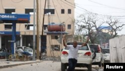 有人逃离摩加迪沙机场附近的一家酒店的自杀炸弹爆炸现场(2016年6月25日)