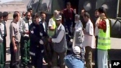 资料照:阿富汗和中国官员在喀布尔从直升机上运下装有在昆都士被杀害的中国修路工人的尸袋。(2004年6月11日)