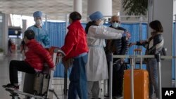 医务人员在北京国际机场检测从海外抵达的旅客体温。(2020年3月12日)