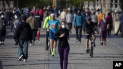 图为人们正在穿越西班牙马德里的托莱多大桥,周六,西班牙人能够外出锻炼,这是自封锁开始抗争以来的七周来的第一次。(2020年5月3日)