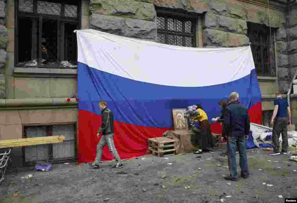 Phụ nữ đặt hoa tưởng niệm những người thiệt mạng trong vụ đụng độ trên đường phố giữa dân quân thân Nga và người ủng hộ Ukraine bên ngoài tòa nhà liên hiệp thương mại tại Odessa, ngày 4/5/2014.