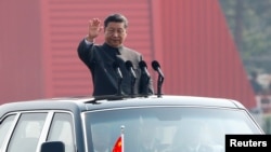 中国国家主席习近平在北京天安门广场举行的阅兵式上乘车检阅。(2019年10月1日)