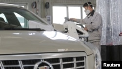 中国北京一家凯迪拉克4S店的工人正在修理汽车。(2016年3月14日)