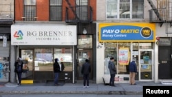 2020年4月2日人们排队进入纽约市曼哈顿一家提供支票兑现公司。