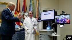 美国总统川普在白宫罗斯福室举行的退伍军人事务部“远程医疗服务”活动中在退伍军人事务部部长舒尔金的陪同下与一位患者交谈。(2017年8月3日)