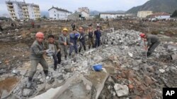 Tư liệu - Những người công nhân đang bê các khối bê tông tại khu vực bị lũ tàn phá Onsong, tỉnh Bắc Hamgyong, Bắc Triều Tiên, ngày 16 tháng 09 năm 2016.