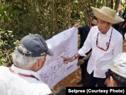 Presiden Jokowi dan Menteri PUPR Basuki Hadimuljono berdiskusi di atas peta kawasan Palangkaraya dan sekitarnya (courtesy: Setpres)