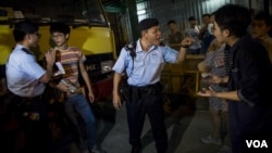 在香港旺角商业区的一场本土派示威中,警察检查“本土民主前线”的发言人黄台仰(左起第二人)的身份证(2015年6月21日)