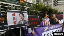 香港民主抗议者举着铜锣湾书店老板桂民海(左)和李波(右)的肖像。(2016年1月19日)