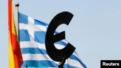 在布鲁塞尔欧洲议会大楼外面,希腊国旗在欧盟标徽后面飘扬。