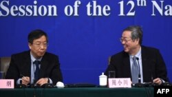 2015年3月12日在北京召开的第十二届全国人民代表大会第三次会议期间,中国人民银行行长周小川(右)和副行长易纲(左)召开新闻发布会。