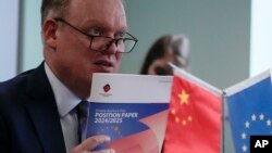 中国欧盟商会会长彦辞(Jens Eskelund)在北京举行的记者会上手拿一本年度欧洲企业在中国立场的报告书。(2024年9月11日)