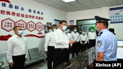 资料照:中国领导人习近平在新疆乌鲁木齐市视察一个当地的派出所。(2022年7月14日)