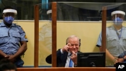 波黑塞族前军队总司令姆拉迪奇在荷兰海牙的国际法庭上模仿拍照动作。(2021年6月8日)