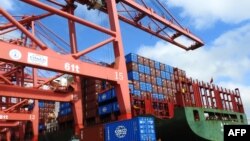 2018年7月13日,中国江苏省东部连云港的一个港口,起重机,卡车和集装箱。