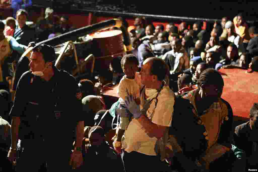 Migrants arrive by rescue boat with a group that includes Syrian refugees, Pozzallo harbor, Sicily, Sept. 17, 2013.