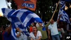 希腊公布了最新的全民公投结果之后,表示不接受债权人救助方案的人挥动希腊国旗