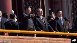 在“纪念中国人民抗日战争暨世界反法西斯战争胜利70周年”阅兵时,中国主席习近平和前主席江泽民交谈。胡锦涛在旁边(2015年9月3日)