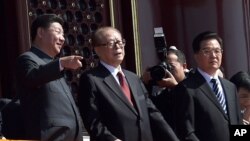 在“纪念中国人民抗日战争暨世界反法西斯战争胜利70周年”阅兵时,中国主席习近平和前主席江泽民交谈。胡锦涛在旁边(2015年9月3日)