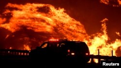 加利福尼亚州洛杉矶以北的野火10月25日借助风力继续燃烧,对当地民众造成威胁。