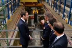 资料照片:在布雷斯特附近的克罗宗海军潜艇基地,法国总统马克龙在一艘法国核潜艇前听取汇报。(2017年7月4日)