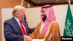 Putra Mahkota Arab Saudi Mohammed bin Salman berjabat tangan dengan Presiden AS Donald Trump, di KTT para pemimpin G20 di Osaka, Jepang, 29 Juni 2019. (Foto: Bandar Algaloud/Courtesy of Saudi Royal Court via REUTERS)
