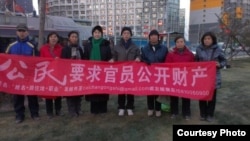 胡佳(右四)等在北京朝阳区闹市区举牌要求中共官员向社会公示财产。(胡佳推特图片)