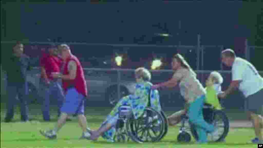 Người bị thương được đưa ra xe cứu thương từ sân bóng bầu dục sau vụ nổ nhà máy phân bón gần Waco.