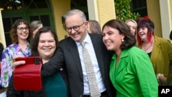 2024年3月8日,澳大利亚总理安东尼·阿尔巴内斯(中)在堪培拉总理官邸举行的国际妇女节早茶会期间与当地妇女支持组织的代表合影留念。