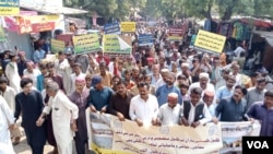 2024年10月20日,在巴基斯坦塔帕卡的伊斯拉姆科特,游行队伍经过这里的一个主要集市,高呼反对燃煤电厂和塔尔煤矿项目的口号。