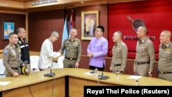 在泰缅边境附近遭电诈集团绑架的中国演员王星(左三)被泰国警方找回后与泰国警官握手。(2025年1月7日 )