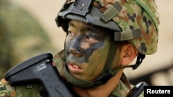 2023年11月19日,在日本西南部鹿儿岛县德之岛,一名日本陆上自卫队两栖快速部署旅(ARDB)士兵参加海上登陆演习,这是日本全国05JX军事演习的一部分。(路透社)