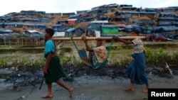 Người tị nạn Rohingya gánh một người phụ nữ tới trại tị nạn dựng tạm ở Cox's Bazar, Bangladesh, ngày 13 tháng 9, 2017.