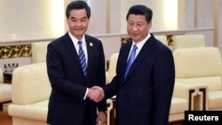 2014年11月9日中国国家主席习近平(右)在北京人民大会堂和香港特区行政长官梁振英(左)会面握手