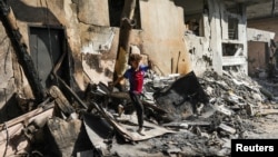 Seorang anak laki-laki berjalan di antara puing-puing akibat serangan Israel di kamp pengungsi Nuseirat, Jalur Gaza, pada 9 Juni 2024, saat jumlah korban tewas Palestina meningkat menjadi 274 di tengah konflik Israel-Hamas. (Foto: Abed Khaled/Reuters)