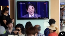 韩国人观看电视报道日本首相安倍就二战结束70周年发表谈话(2015年8月14日)